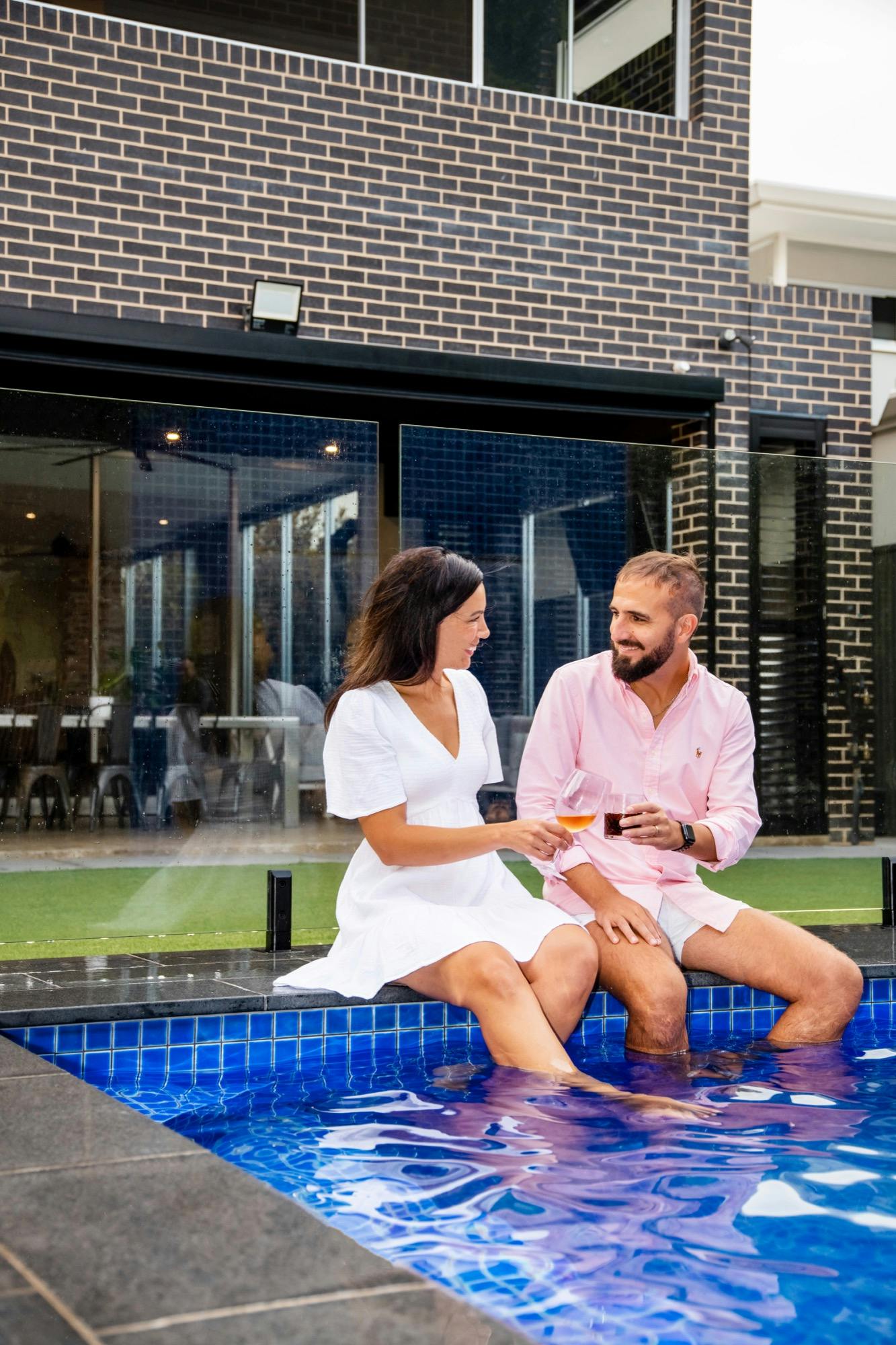 Swimming pool and couple drinking wine